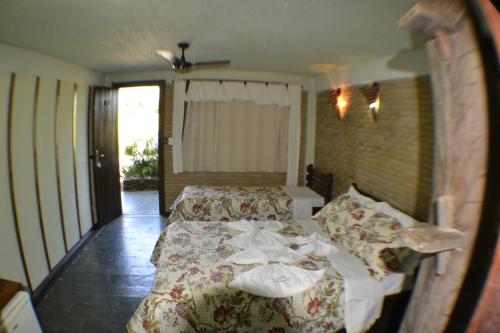 a bedroom with two beds and a ceiling fan at Pousada Morro Encantado in Cavalcante
