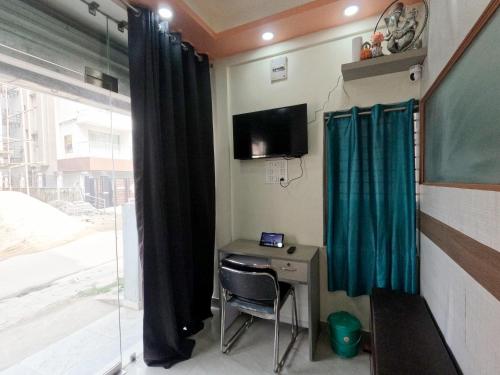 a room with a desk and a tv and a window at Utopia Guest house for men in New Town