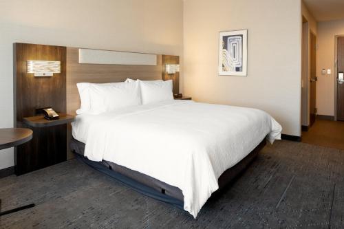 a large white bed in a hotel room at Holiday Inn Express & Suites Lathrop by IHG in Lathrop
