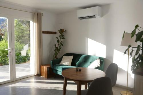 a living room with a green couch and a table at Villa Foia Vella - adults only in Benichembla