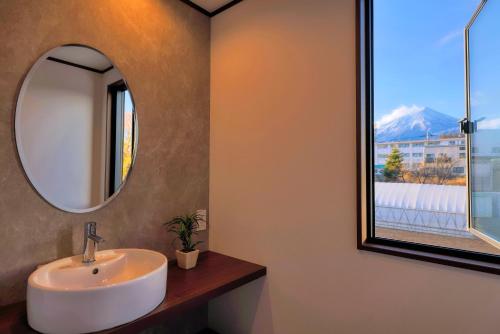 a bathroom with a sink and a mirror at Villas Fuji Sengen ヴィラス富士浅間 in Fujiyoshida