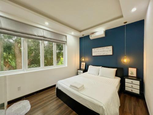 Un dormitorio con una cama y una pared azul. en 4 Bedrooms Villa in Vung Tau- The Green Mountain Villa in Vung Tau, en Vung Tau