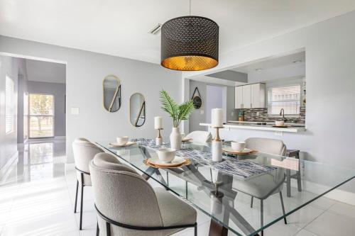 a dining room with a glass table and chairs at Heart of Sunrise and Sawgrass in Sunrise