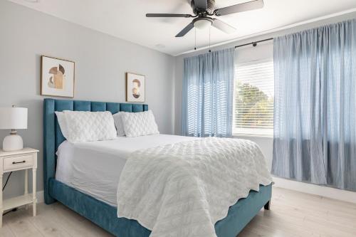 a bedroom with a blue bed and a ceiling fan at Heart of Sunrise and Sawgrass in Sunrise