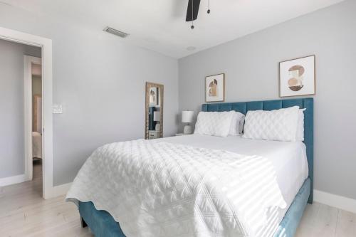 a bedroom with a large bed with a blue headboard at Heart of Sunrise and Sawgrass in Sunrise