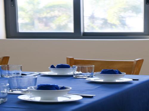 a blue table with plates and bowls with blue napkins at Lucky Star Ho Tram Hotel & Restaurant in Ho Tram