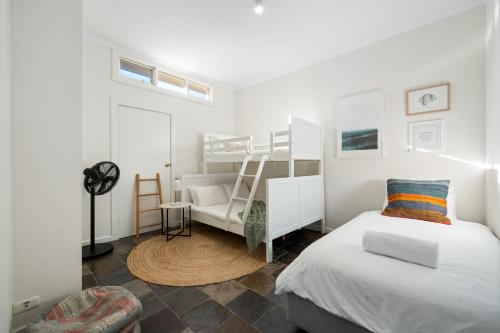 una camera da letto con un letto a castello e una sedia di Seaside on Swan - Nespresso Beach Wifi a Grange
