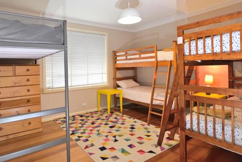 a bedroom with two bunk beds and a rug at Two Pines, whole home in Tullamarine near airport! in Melbourne