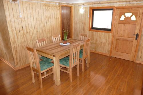 a dining room with a wooden table and chairs at Parques de Afunalhue in Licán Ray