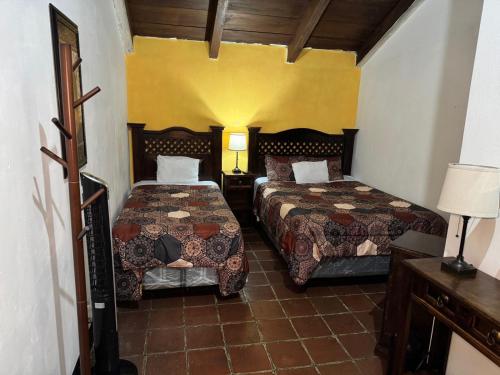 a hotel room with two beds and two lamps at Hotel y Restaurante San Fernando. in Jocotenango