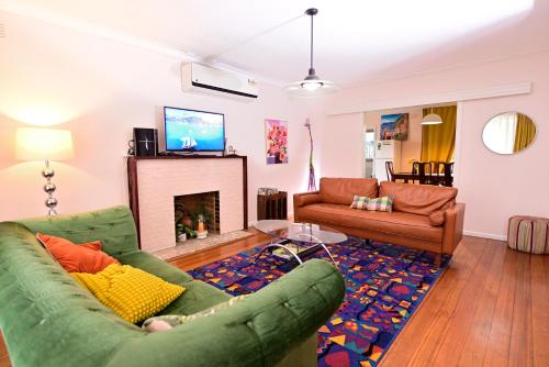 a living room with a couch and a fireplace at Two Pines, whole home in Tullamarine near airport! in Melbourne
