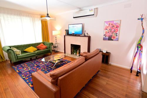 a living room with a couch and a fireplace at Two Pines, whole home in Tullamarine near airport! in Melbourne