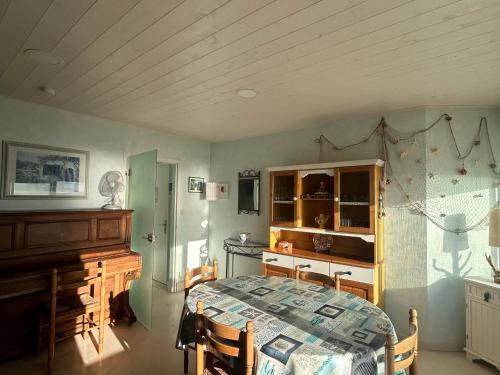 - une cuisine avec une table et un piano dans la chambre dans l'établissement Appartement bord de mer avec balcon et parking - FR-1-652-47, à Saint-Jean-de-Monts
