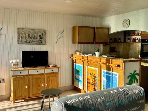 une cuisine avec un canapé et une télévision dans une pièce dans l'établissement Appartement bord de mer avec balcon et parking - FR-1-652-47, à Saint-Jean-de-Monts