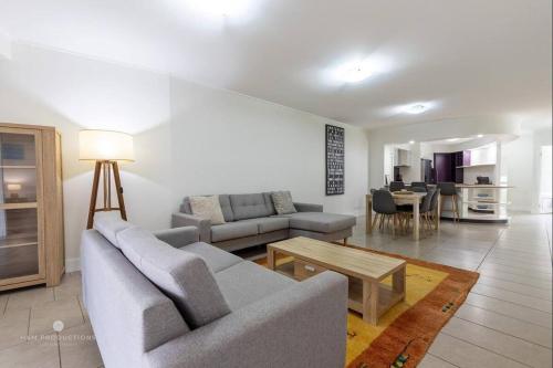 a living room with a couch and a table at Beaches Retreat - 3 BR w Pool - 5 Min to Beach in Agnes Water