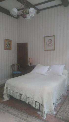 a white bed in a bedroom with a ceiling at hôtel Beaulieu in Viviers