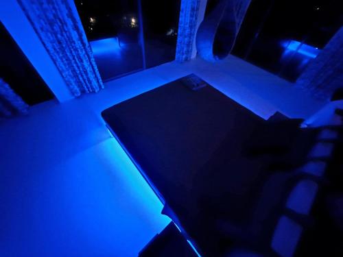 a dark room with a table and a blue light at X Mirissa in Mirissa