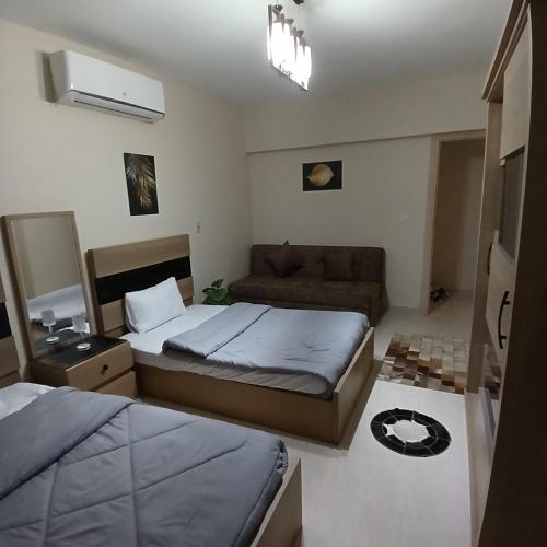 ein kleines Schlafzimmer mit einem Bett und einer Couch in der Unterkunft Fabulous apartment near Gate 20 - El Rehab in Kairo