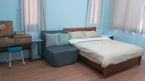 a bedroom with a bed and a desk and a chair at Chin-Lan B&B in Zhuangwei