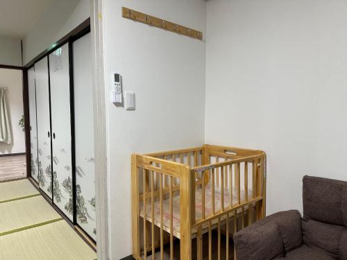 a room with a crib and a couch at An-shao-ya安嶼屋 8minutes walk to JR Teradacho Loop Line Station 13minutes walk to Tennoji Mall in Osaka