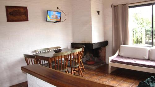 sala de estar con mesa, sillas y TV en Casa 7 Cerros, en Piriápolis