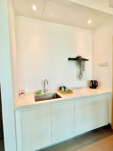 a kitchen with white cabinets and a sink at Imperium Residence Kuantan in Kuantan