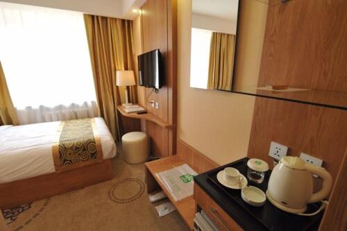 a hotel room with a bed and a table with a table at Flower Hotel Ulaanbaatar in Ulaanbaatar