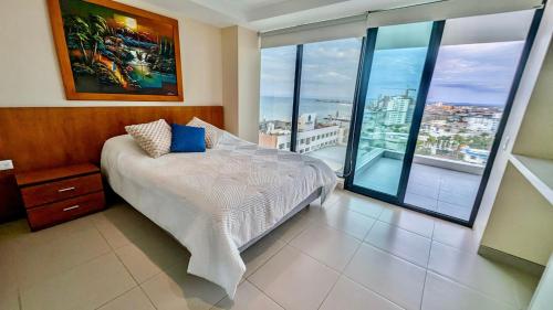 a bedroom with a bed and a large window at Departamento Frente al Mar en Manta Poseidon in Manta