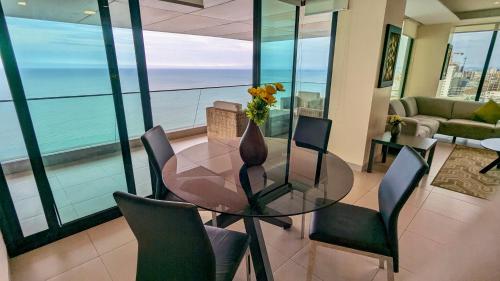 a dining room with a glass table and chairs at Departamento Frente al Mar en Manta Poseidon in Manta
