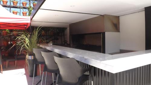 a kitchen with a counter with chairs and a bar at Casa Daupi in Mar del Plata