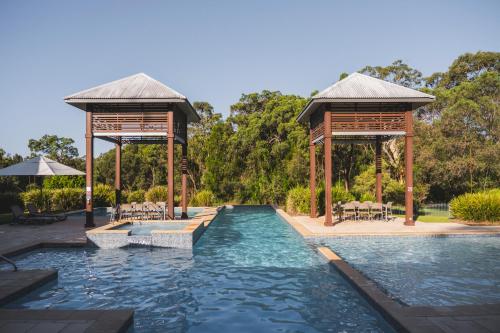 a swimming pool with two gazebos and a swimming poolvisor at Senses Noosa North Shore in Noosa North Shore