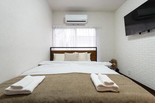 a bedroom with a bed with two towels on it at ohayo旅館 東矢口 in Tokyo