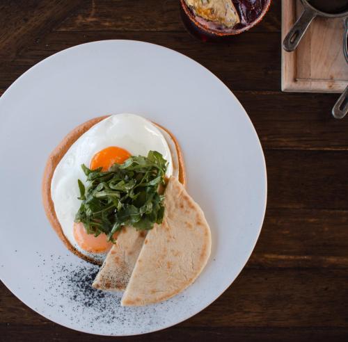 a white plate with an egg and greens on it at Casa 1810 Hotel Boutique in San Miguel de Allende