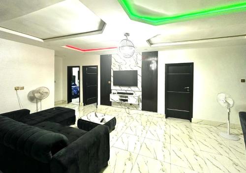 a living room with couches and a flat screen tv at KOLS Apartment in Lagos