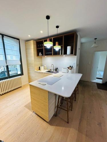 - une cuisine avec une grande île blanche dans une chambre dans l'établissement La Maison du Nice Caennais, à Caen