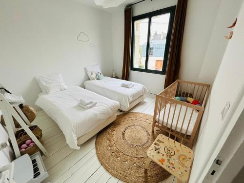 a small room with two beds and a crib at La Maison du Nice Caennais in Caen