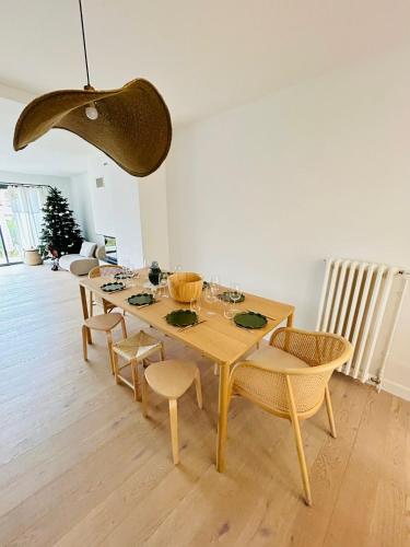 une salle à manger avec une table et des chaises en bois dans l'établissement La Maison du Nice Caennais, à Caen