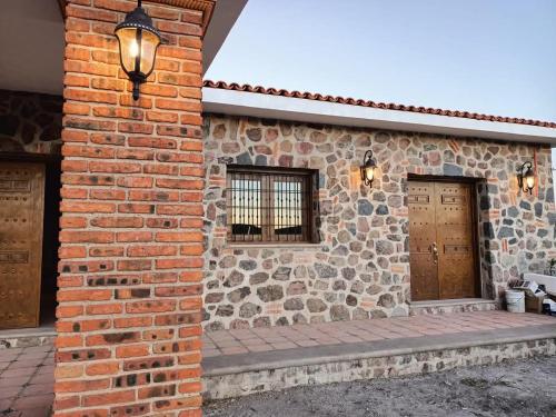 a brick building with two doors and two windows at Cabañas calpulalpan de paso in San Cristóbal Zacacalco