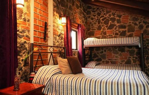 a bedroom with a bed and a brick wall at Cabañas calpulalpan de paso in San Cristóbal Zacacalco