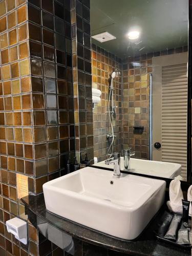 a bathroom with a white sink and a mirror at Karon Boutique in Karon Beach