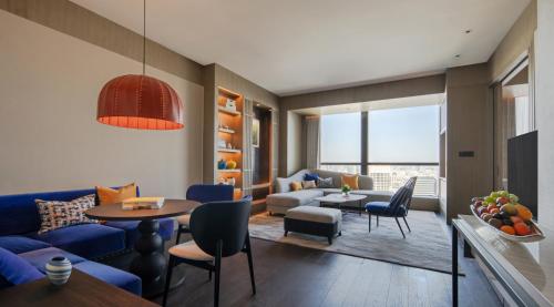 a living room with a blue couch and a table at MGM Shanghai West Bund in Shanghai