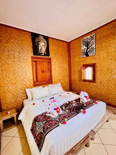 a bedroom with a large bed with a picture on the wall at Bungalow Geringsing in Candidasa