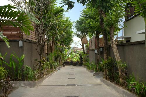 eine leere Gasse mit Bäumen und einem Gebäude in der Unterkunft Canggu Circle Villa by Ini Vie Hospitality in Canggu