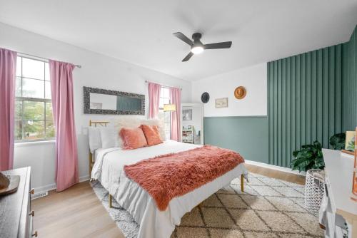 a bedroom with a bed with pink and green curtains at Emerald Horizon by Logan (104 Azalea Ct) in Clarksville