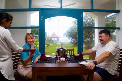 a group of people sitting around a table at Hotel Lanka Super Corals in Hikkaduwa