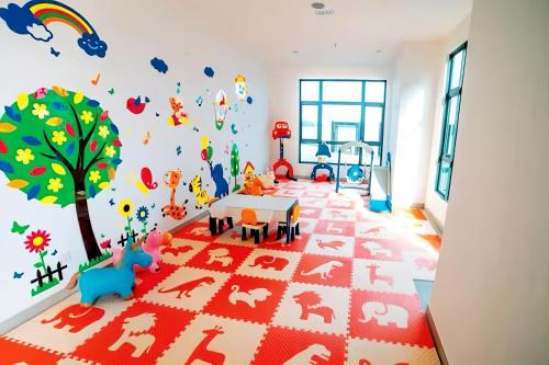 a childs room with a tree and animals on the wall at Imperium Residence Kuantan in Kuantan