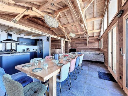 une salle à manger avec une longue table en bois et des chaises dans l'établissement Chalet de luxe près des pistes avec spa, sauna et parking - FR-1-267-303, à Villarembert