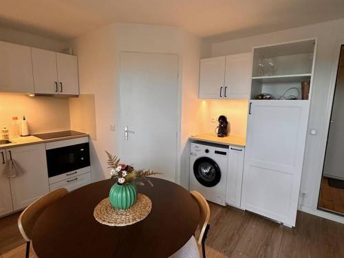 une cuisine avec une table et un vase vert. dans l'établissement Appartement climatisé, 4 pers, plage & parking à Port Leucate - FR-1-81-627, à Port-Leucate