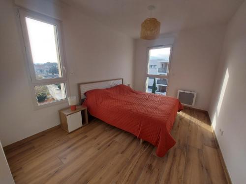- une chambre avec un lit rouge et deux fenêtres dans l'établissement Appartement 4 pers à Argelès-sur-Mer avec clim, WIFI et parking - FR-1-776-117, à Argelès-sur-Mer