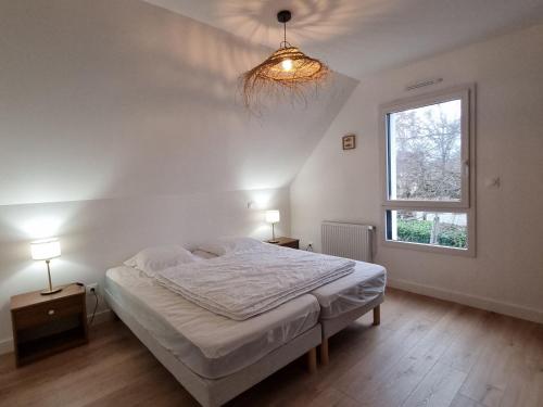 une chambre blanche avec un lit et une fenêtre dans l'établissement Maison moderne 6 pers, plage et Internet à 900m, animaux acceptés - FR-1-775-4, à Le Tour-du-Parc